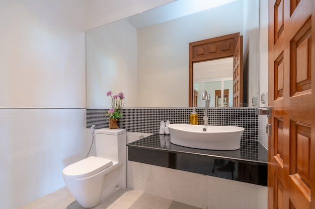 Interior real bathroom features basin, toilet bowl