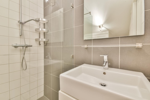 Interior of a shower cabin with a glass wall and a ceramic sink in a modern house