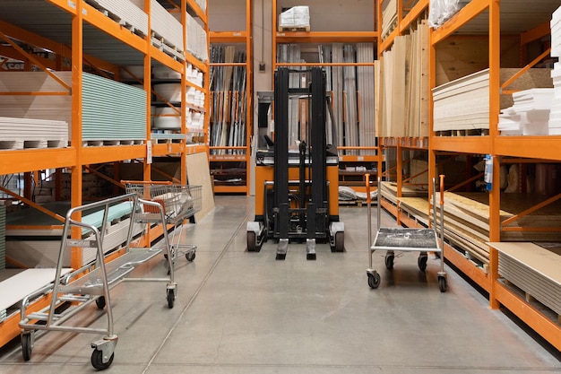 Interior of a simple shop selling drywall and plywood with a forklift between the rows