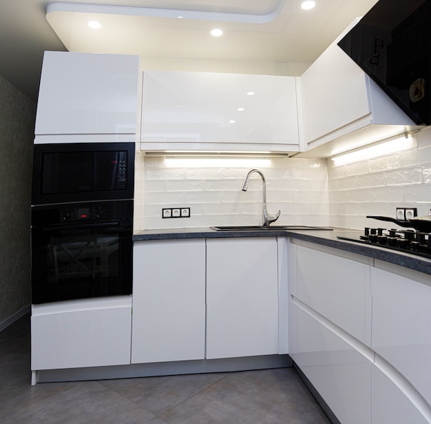 interior of a small white kitchen with modern household appliances