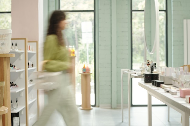 Interior of spacious beautycare supermarket with blurry motion of consumer