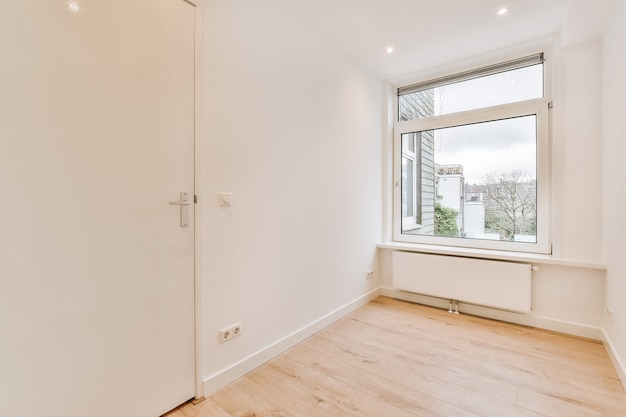 Interior of spacious empty room with white walls and parquet floor in new apartment