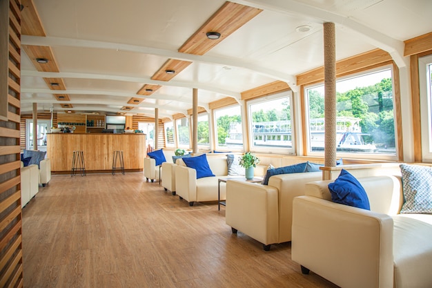 The interior of the urban river ship with a panoramic view of the urban landscape