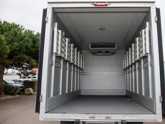 Interior van of an empty panel truck with large doors open on empty place small vehicle