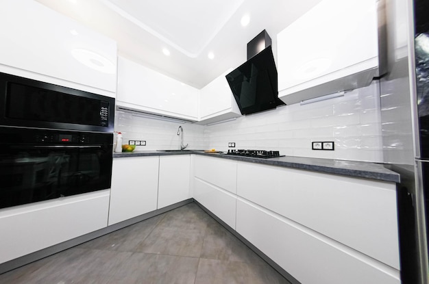 interior of a white kitchen of compact size with builtin modern appliances