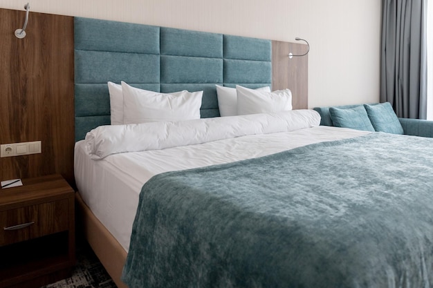 Interior with blue white colors Bedroom with bed white bedding White pillows duvet and duvet case on bed with blue headboard relax comfortable apartment selective focus