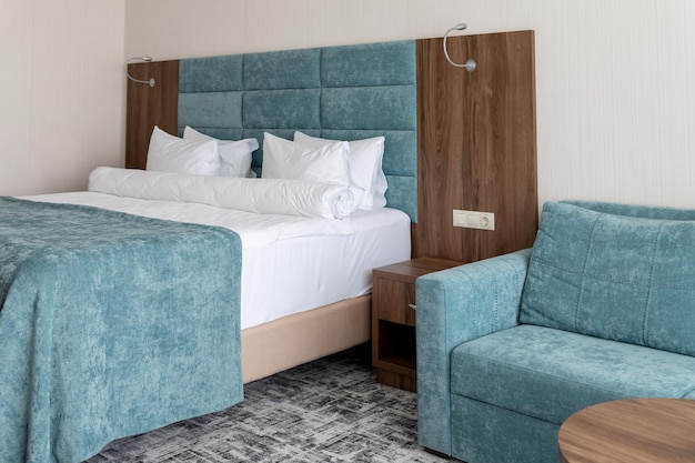 Interior with blue white colors Bedroom with bed white bedding White pillows duvet and duvet case on bed with blue headboard relax comfortable apartment selective focus