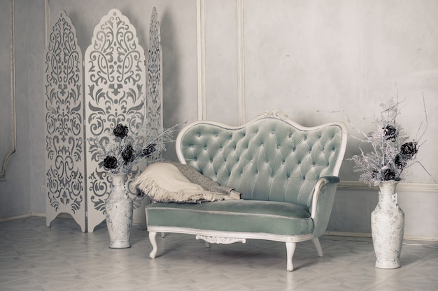 Interior with vintage furniture, light spring studio with beautiful white sofa. White interior of studio.