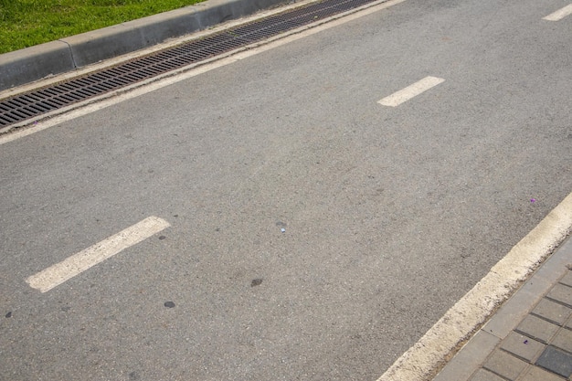 An intermittent lane marking line and the direction of traffic on an asphalt road