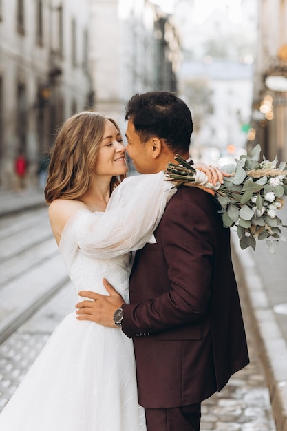 An international wedding couple a European bride and an Asian groom walk around the city together