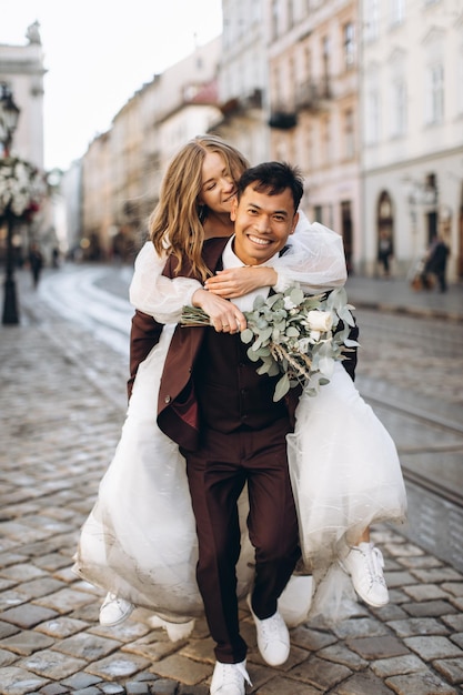 An international wedding couple a European bride and an Asian groom walk around the city together