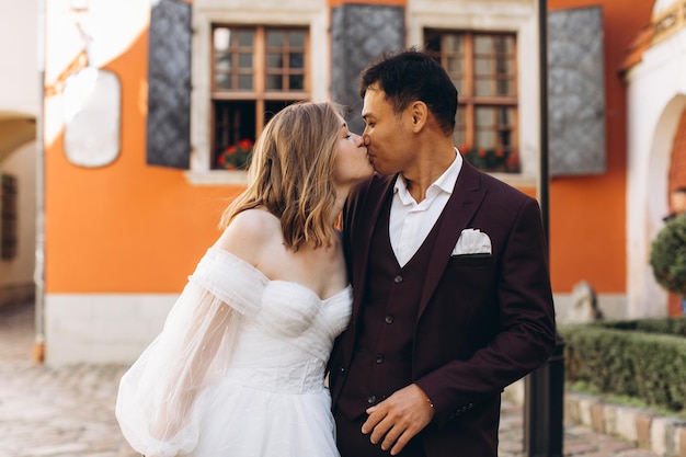 An international wedding couple a European bride and an Asian groom walk around the city together