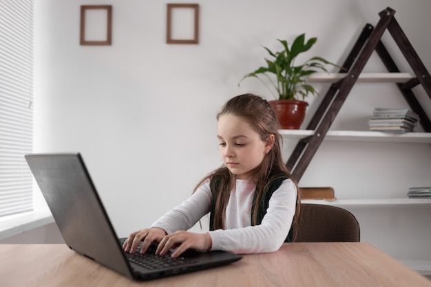 internet addicted child schoolgirl sits at a laptop quickly 