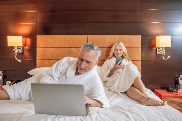 On internet. Couple in bath robes spending time online