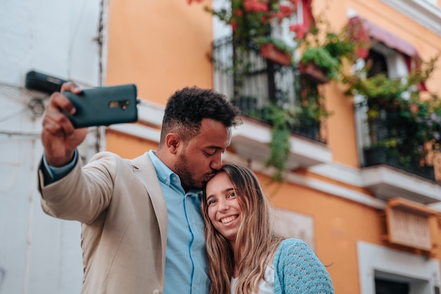 Interracial couple of an African American boy and a Caucasian girl taking a selfie while