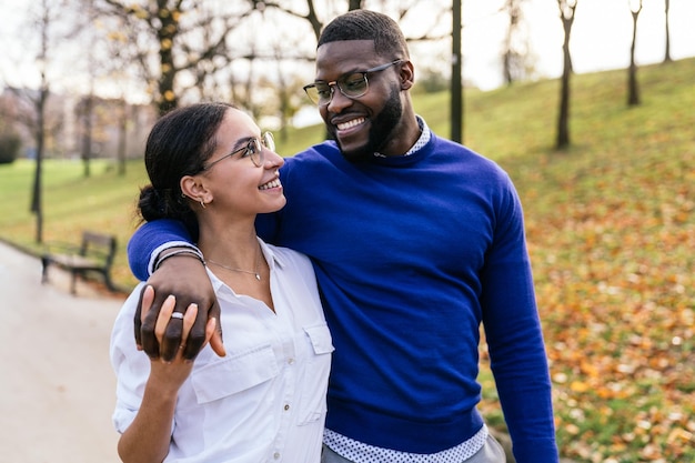 Interracial Couple Embracing in Autumn Park Handsome Black Boy and Beautiful Caucasian Girl Walking and Smiling Happily at Sunset