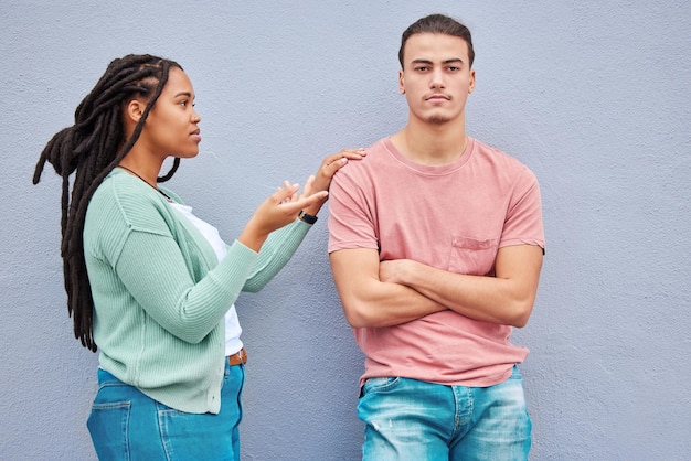 Interracial couple wall background and argument in metro with black woman question and conversation Young gen z man partner and conflict in city with relationship fight and angry arms crossed