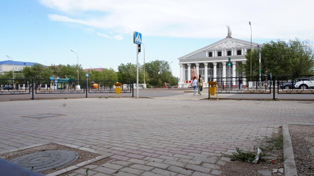 An intersection with cars and people near palace