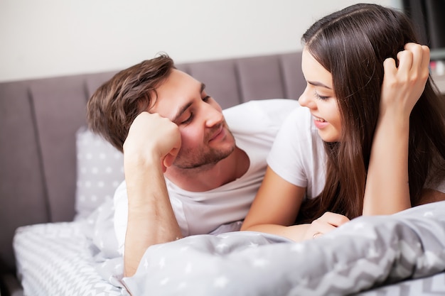 Intimate sensual young couple in bedroom enjoying each other