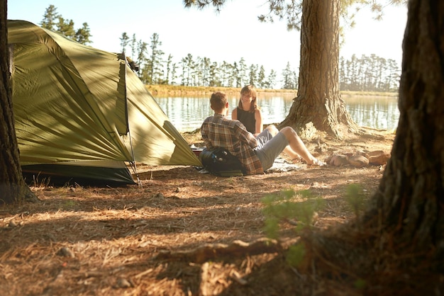 Into the woods Shot of a young couple camping by a lake