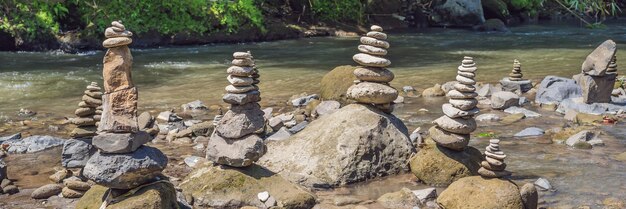 Inuksuk native rock pile in a creek banner long format