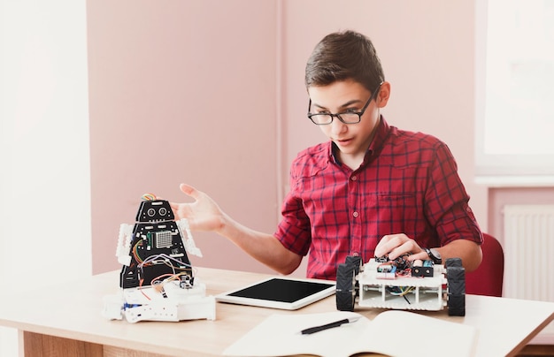 Inventions and creativity for kids. Confused boy made mistake while programming robot on his digital tablet. Gadgets, E-learning, modern teaching technology, STEM education.