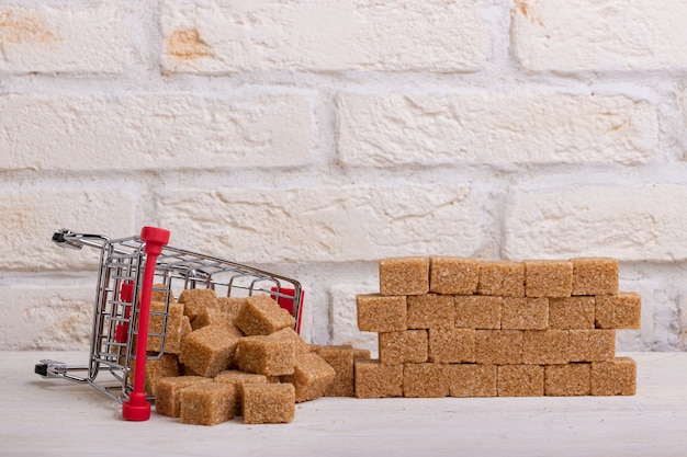 Inverted trolley with brown cane sugar and a wall of their sugar cubes