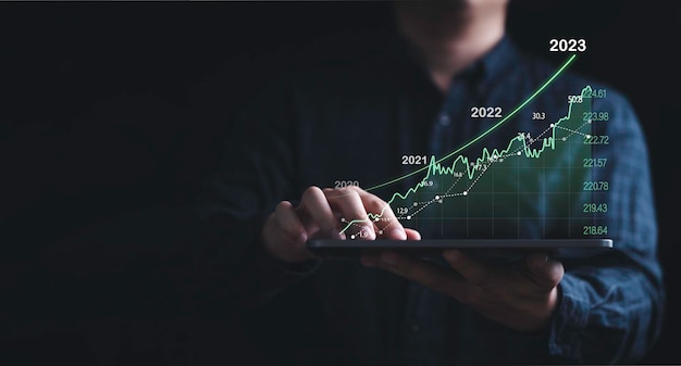 Investor holding tablet with increasing stock market graph chart for trader technical analysis concept