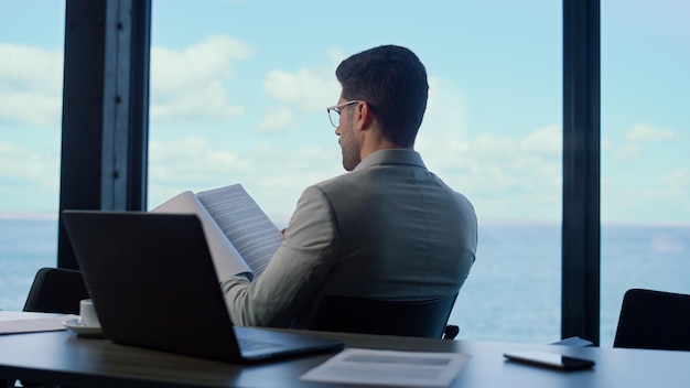 Investor reading contract papers at sea view Businessman professional at work