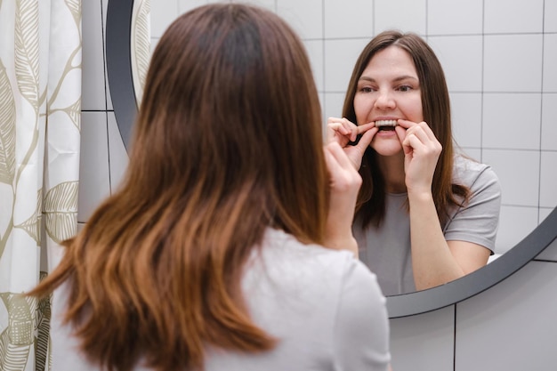 Invisible plastic teeth aligners in hands and putting on braces Beautiful and healthy smile