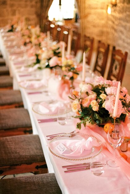 Invitations lie on knotted napkins on plates on a long festive table in a restaurant