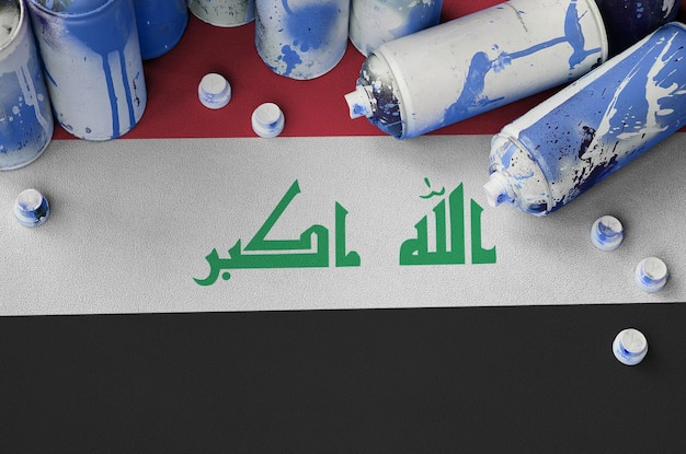 Iraq flag and few used aerosol spray cans for graffiti painting Street art culture concept