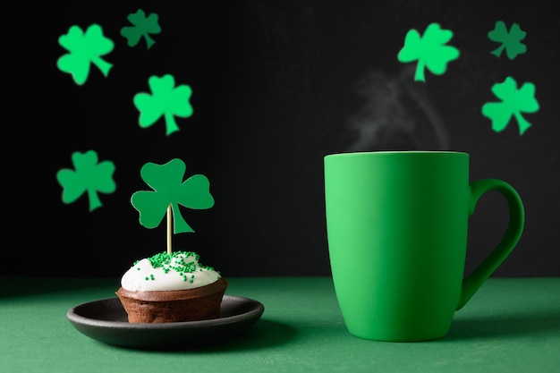 Irish coffee in green cup and special cupcakes for St Patrick s Day