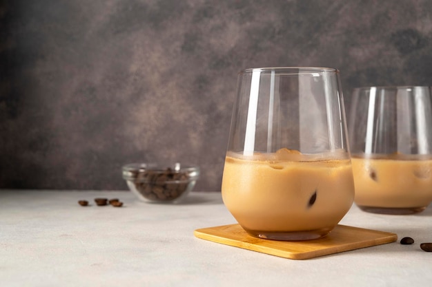 Irish cream liqueur in two glasses with ice cubes and coffee beans copy space for text