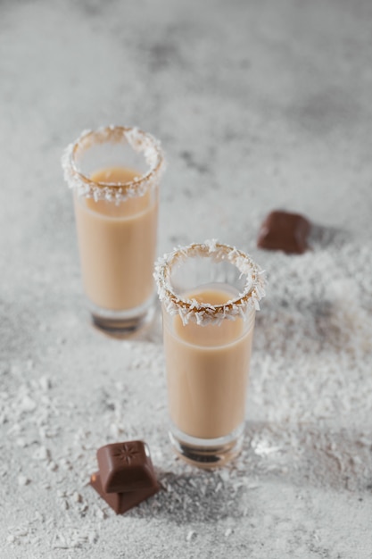 Photo irish cream liquor or coffee liqueur with coconut flakes crown on top of short glass. whinter holiday decorations