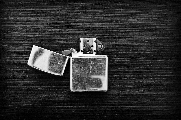 Iron lighter on a dark wooden table in black and white