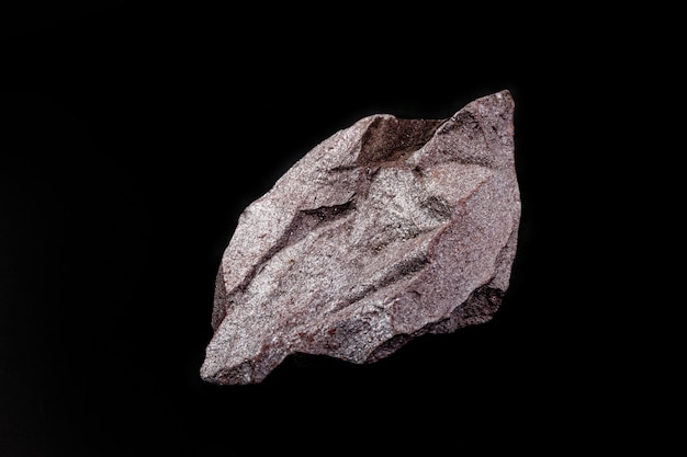 Iron ore on isolated black background, metal used in metallurgical industry.