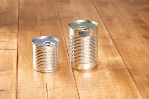 Iron tin can with tab opener on the wooden table.