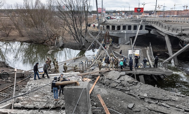 IRPIN UKRAINE Mar 05 2022 War in Ukraine People cross a destroyed bridge as they evacuate the city of Irpin northwest of Kyiv during heavy shelling and bombing