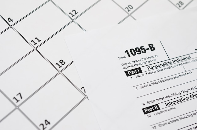 IRS Form 1095B Health Coverage tax blank lies on empty calendar page