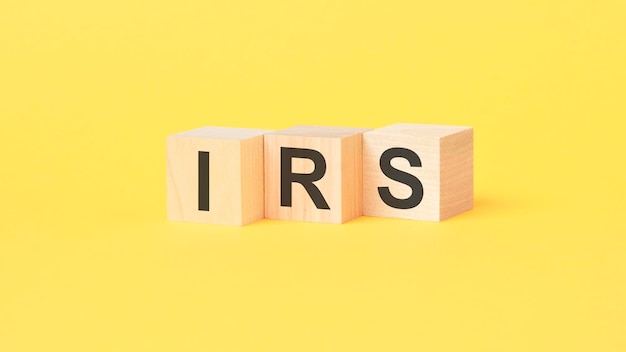 IRS text on wooden cubes on yellow background Internal Revenue Service concept