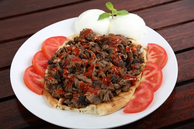 Iskander Kabab with bread and tomato slice served in a dish isolated on table side view of middle east food