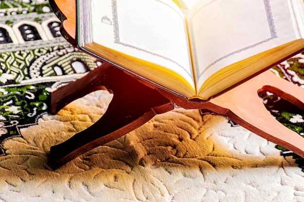 Islam holy book of Muslims the Quran is placed on a wooden stand on the carpet