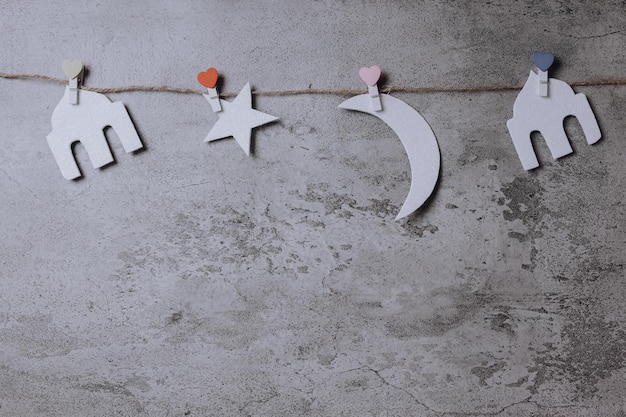 Islamic decoration, shape of mosque, star and moon hang on rope isolated on gray background