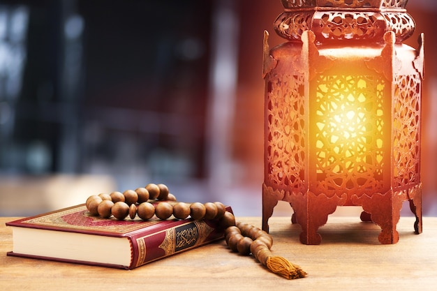 Islamic Holy Book Quran with rosary beads and ornamental arabic lantern