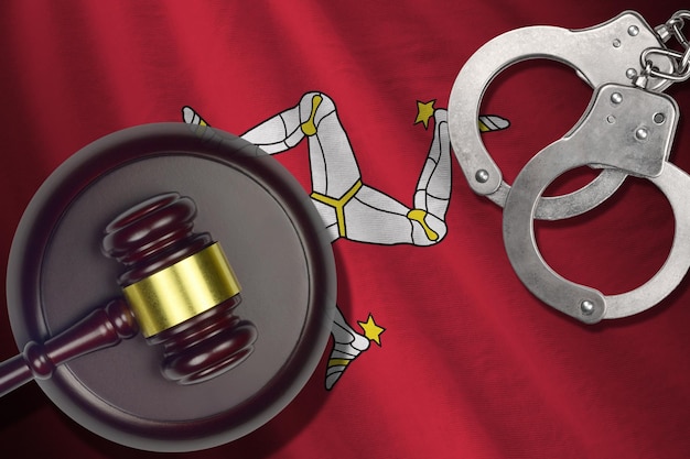 Isle of Man flag with judge mallet and handcuffs in dark room Concept of criminal and punishment background for judgement topics