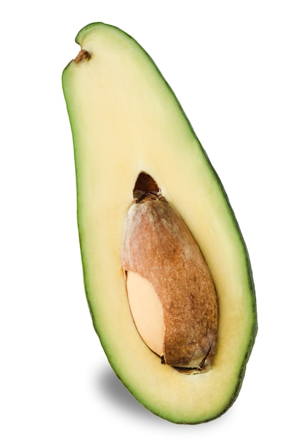 Isolate - half of a long avocado with a stone on a white background. Close-up with a copy space for the text. Vertical orientation.