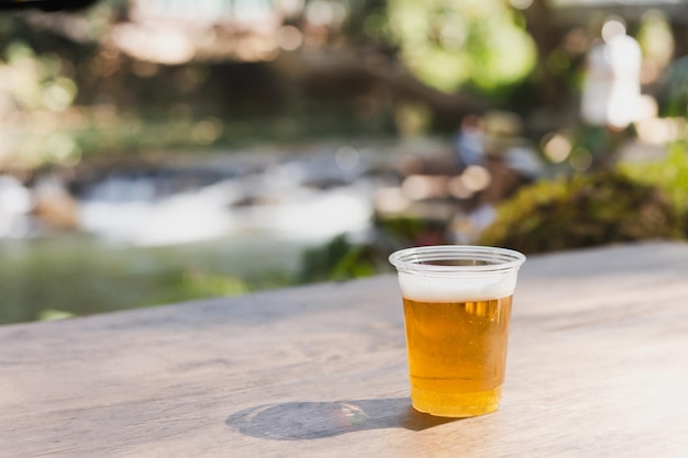 Isolated of beer in plastic glasse on wooden table