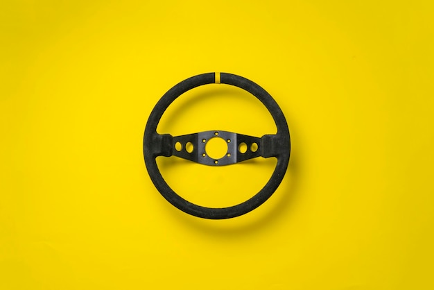 The isolated car steering wheel on the flat surface simple transportation concept