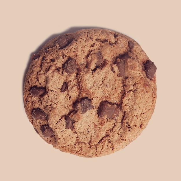 Isolated chocolate chip cookie on brown background